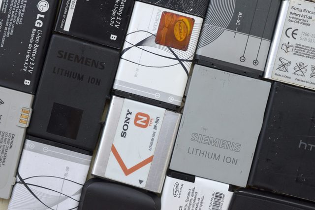 Various smartphone batteries are arranged together; brands like Siemens, Nokia, Sony, and LG are visible, featuring different sizes and designs.