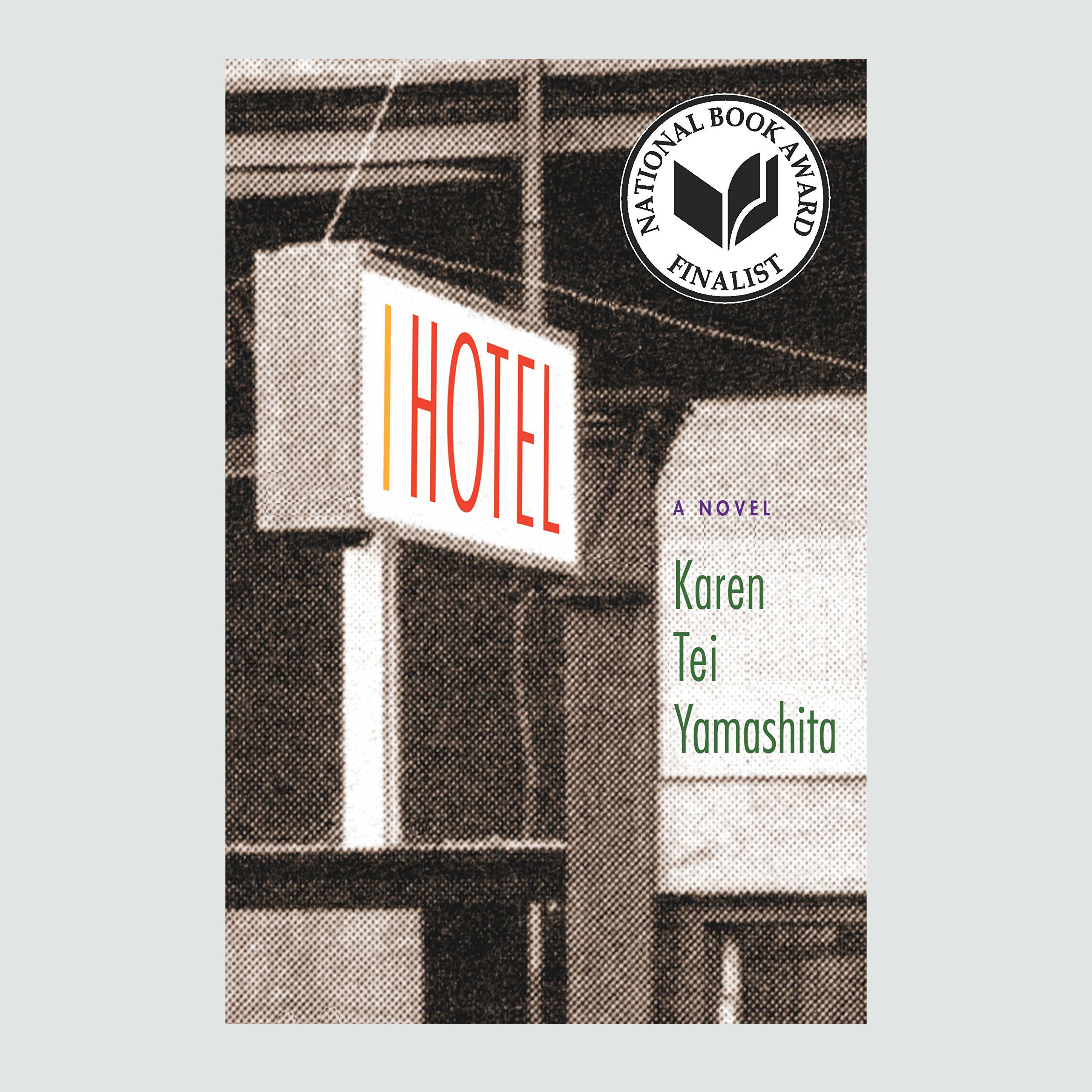Sign displays "HOTEL" in bold red, attached to a building. Text: "A Novel," "Karen Tei Yamashita." National Book Award Finalist emblem present.