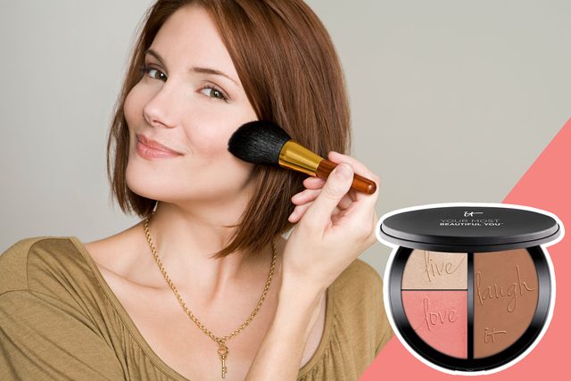 A person applies makeup with a brush, smiling slightly. Nearby, a makeup compact with three shades reads, 