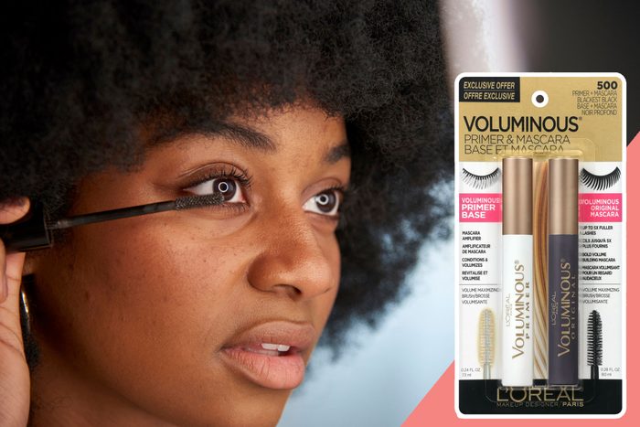 Woman applies mascara, focusing on eyelashes. Packaging for L'Oreal Voluminous Primer and Mascara is featured beside her, highlighting an exclusive offer.