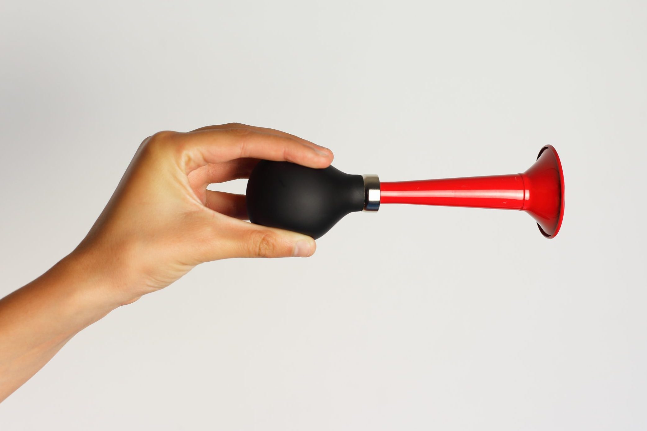 hand holding a horn on gray background