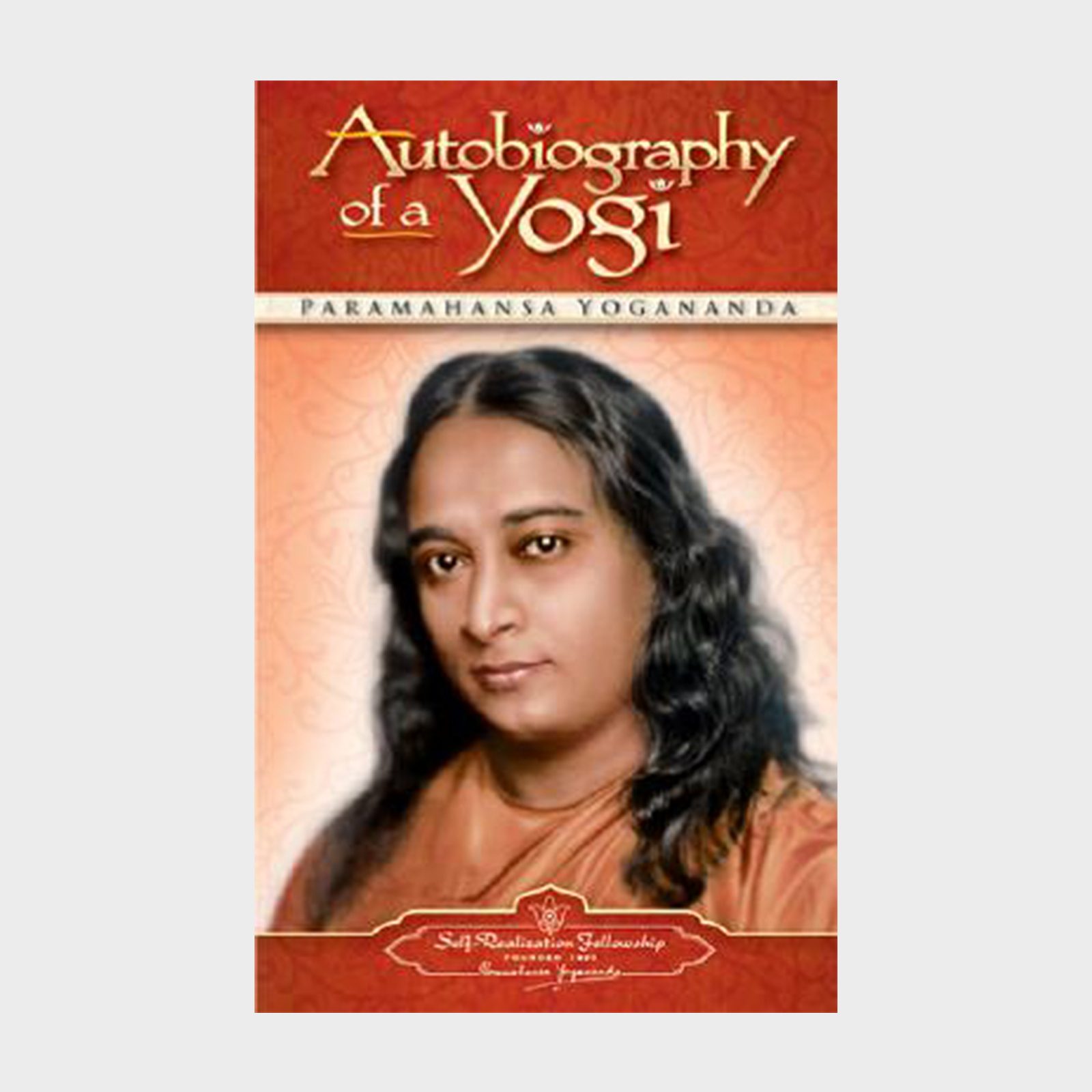 Book cover displays a portrait of a person against an orange backdrop, titled "Autobiography of a Yogi" by Paramahansa Yogananda; ornate design surrounds text.