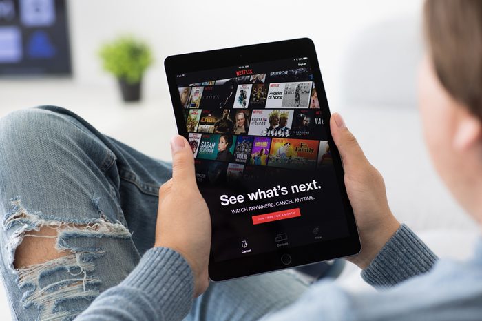 Alushta, Russia - June 8, 2017: Man holding iPad Pro with multinational entertainment company Netflix provides streaming media and video on the screen.