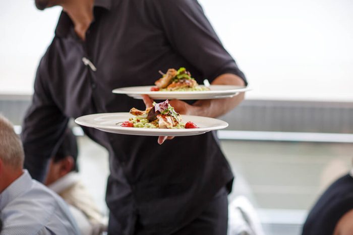 Waiter carrying a plate with salad dish on a wedding
