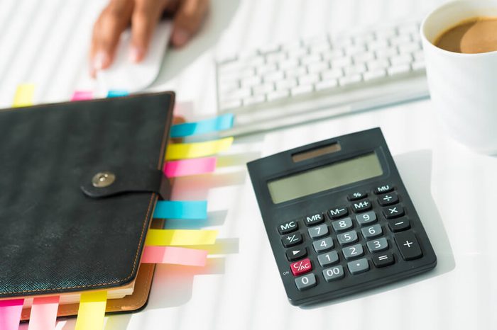 Close-up of a business workplace with an organizer, a calculator and a cup of coffee