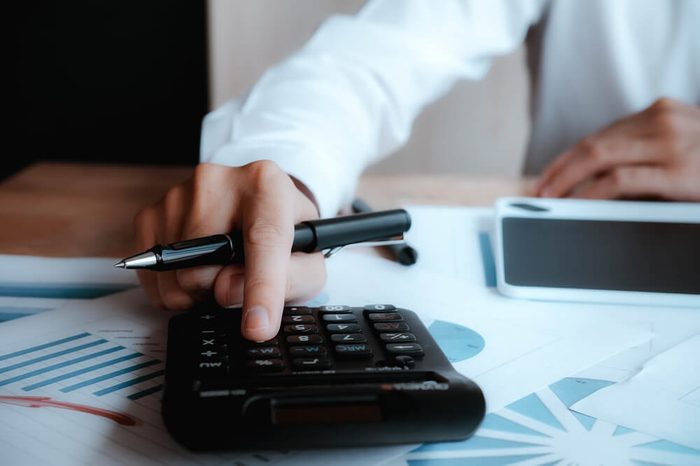 Close up asian Business man using a calculator to calculate the numbers.Business finances and accounting concept