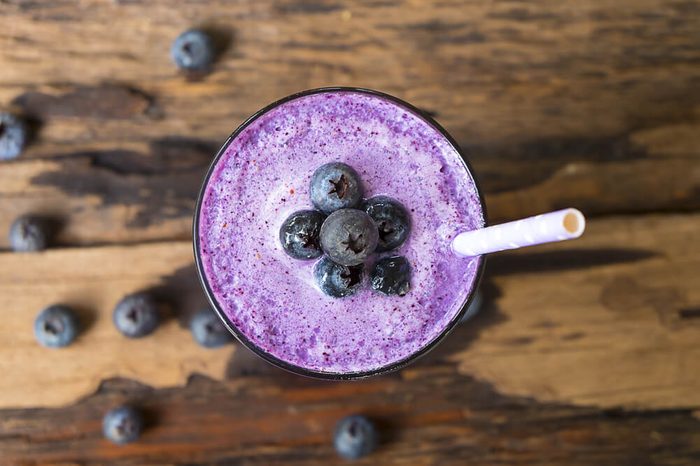 Blueberry smoothies on wooden floor from top view.