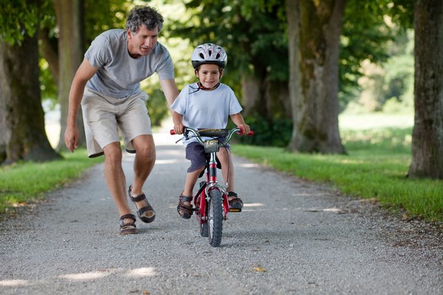Father teaching his son to ride a bike
