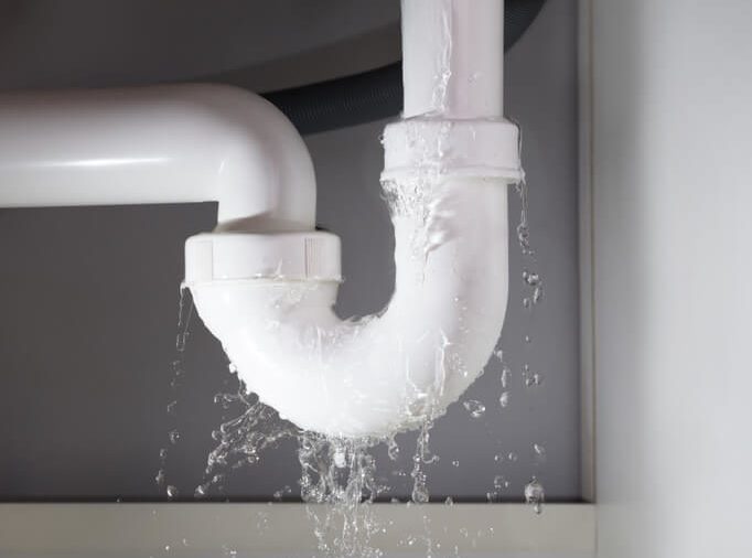 Close-up Of Water Is Leaking From The White Sink Pipe