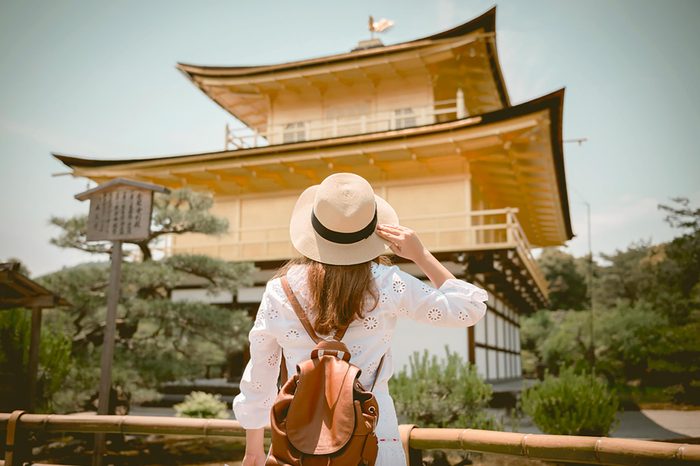 Lady tourist is watching Kinkaku-ji temple in Kyoto, Japan
