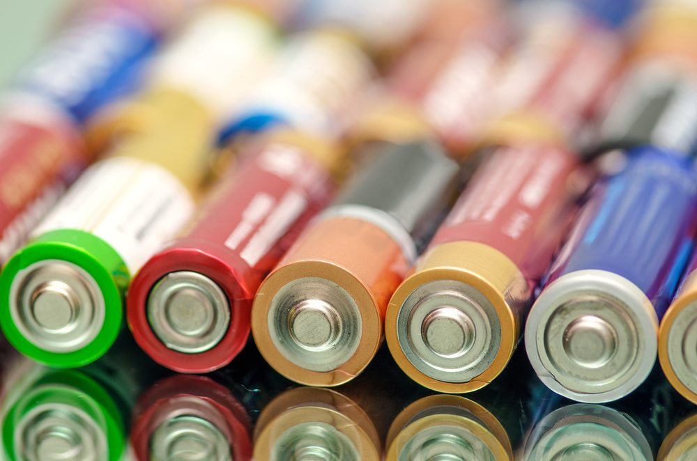 Closeup of pile of used alkaline batteries. Closeup colorful rows of selection of storage batteries energy background of colorful storage batteries. Alkaline battery aa size. Several batteries in rows