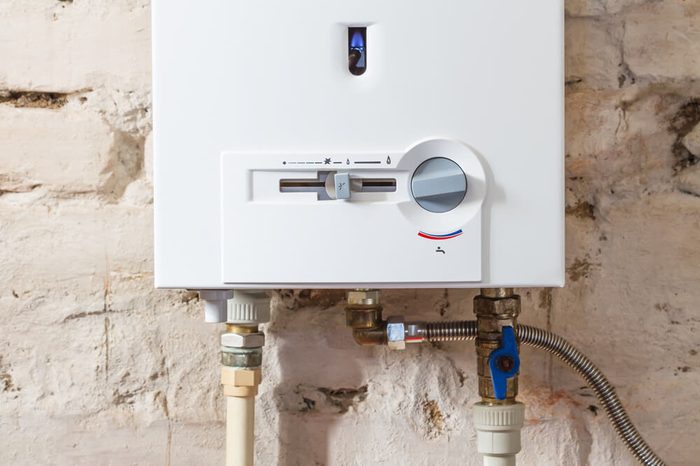 Closeup of gas water heater on a brick wall. Gas boiler in boiler room for hot water