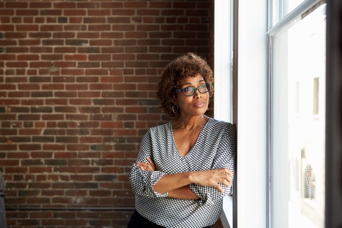 Mature Businesswoman Standing By Office Window