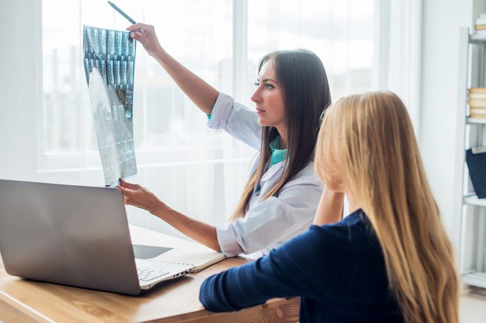 doctor and patient looking at x-ray or MRI concept healthcare, medical and radiology concept