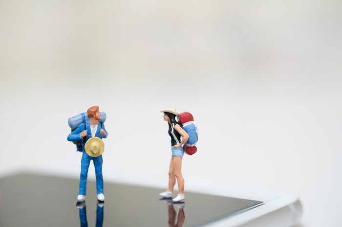 Miniature backpackers standing on smart phone,easy life style with internet concept .Comfortable booking and planning for traveler or travelling reviews with copy space