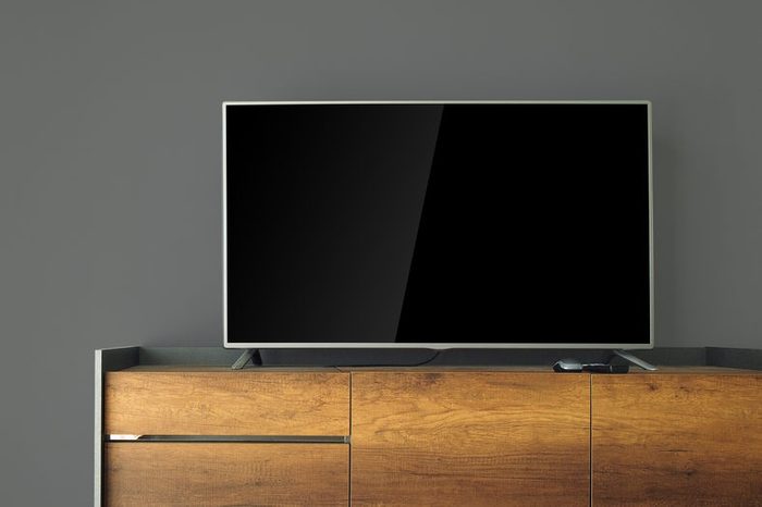 Led TV on TV stand with black wall