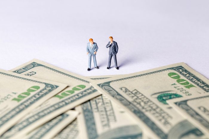 Miniature of investor man looking to money. Business and Investment concept.