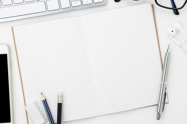 Blank notebook is open on modern white working table. Top view.