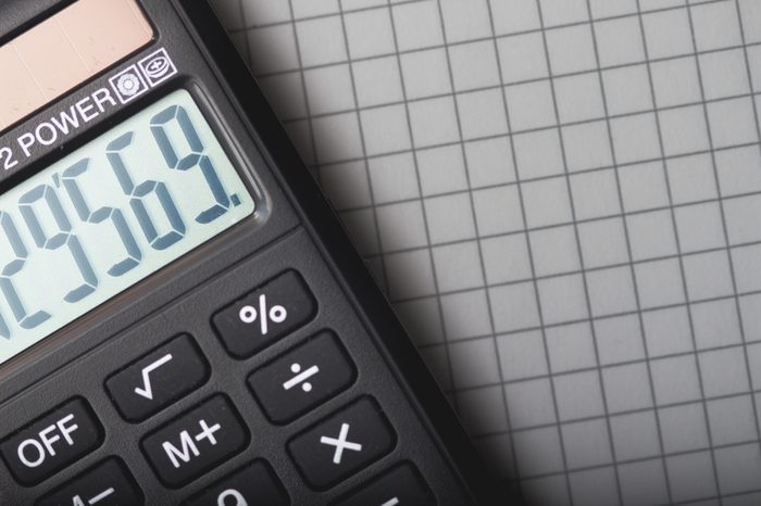 handheld calculator is lying on sheet of paper