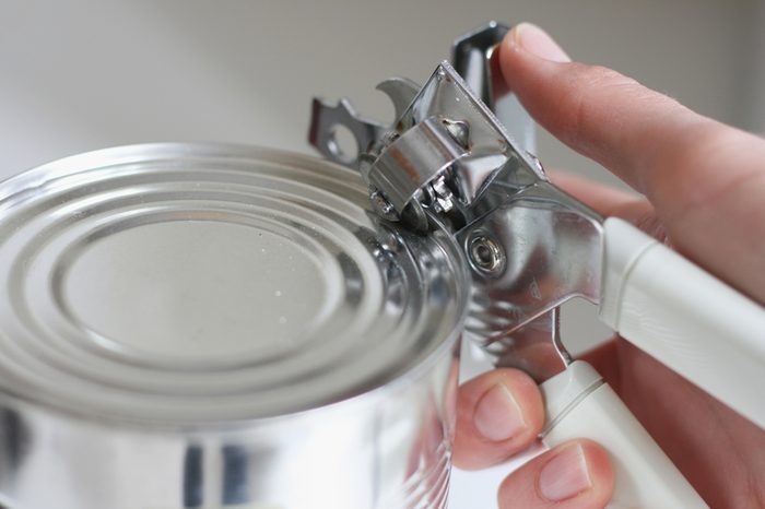 Tin opener opening a can in a kitchen