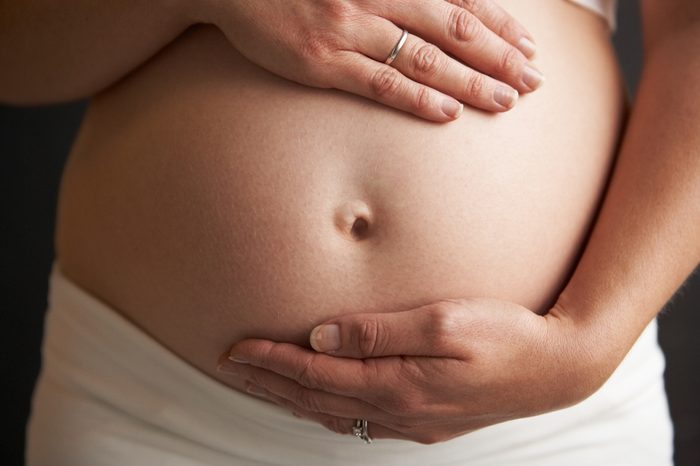 Close Up Portrait Of 5 months Pregnant Woman On Black Background