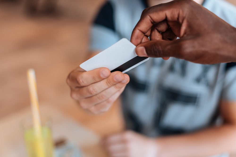 cropped view of african american waiter taking payment with credit card in cafe  