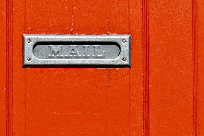 Closeup Of Metal Mail Slot On Orange Door In New Orleans French Quarter