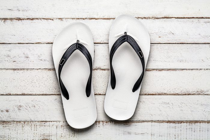White Beach flip flop on white wooden floor