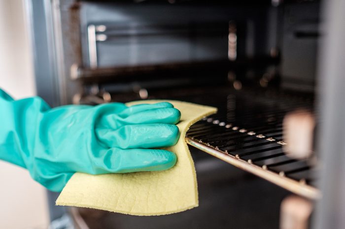 Man's hand cleaning the kitchen oven