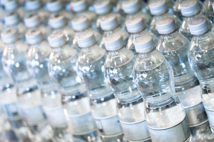 Pure bottled water in small handy bottles for sale on store shelfs. Close up horizontal composition with shallow depth of field.