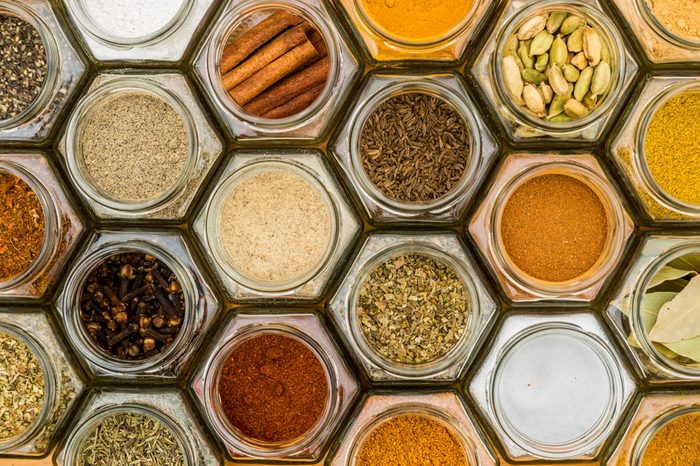 Colorful herbs and spices in hexagonal glass jars. Natural colors and top view. Horizontal picture.