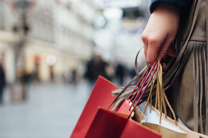 Closeup of woman holding shopping bags on the street with copy space