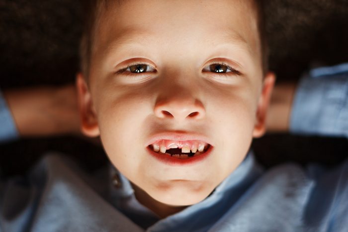 Portrait little boy in fall missing his first milk tooth