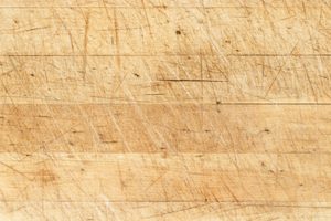 Old and used natural wooden cooking board with cuts