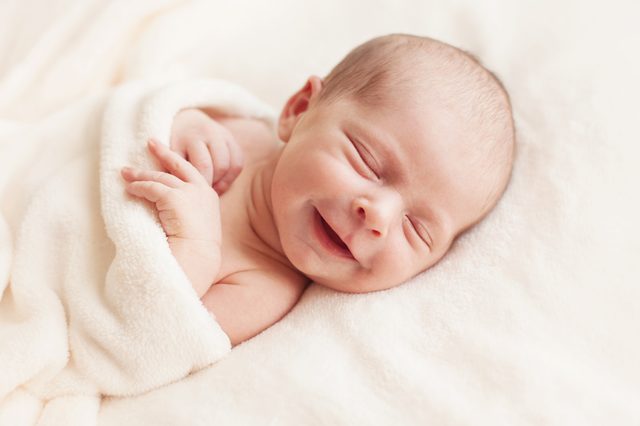 Smiling newborn baby 6 days old