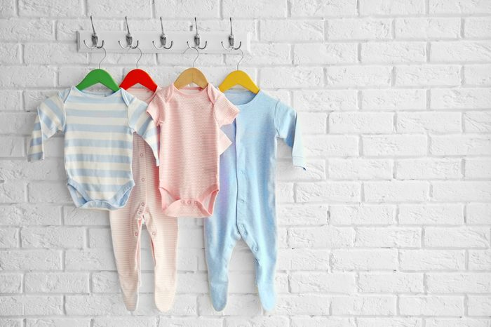 Colorful set of baby romper on brick wall