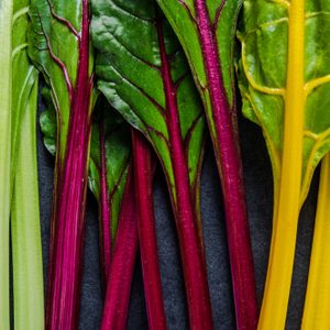 Swiss rainbow chard, vibrant vegetable. Flat lay, from above on dark slate.