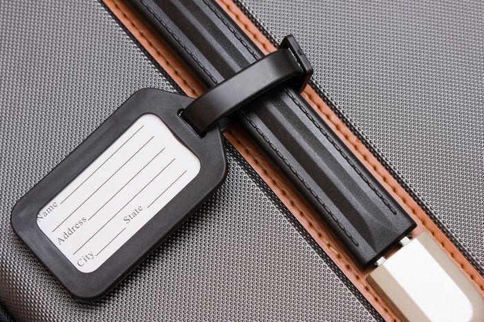 A black luggage tag on a handle on a bag