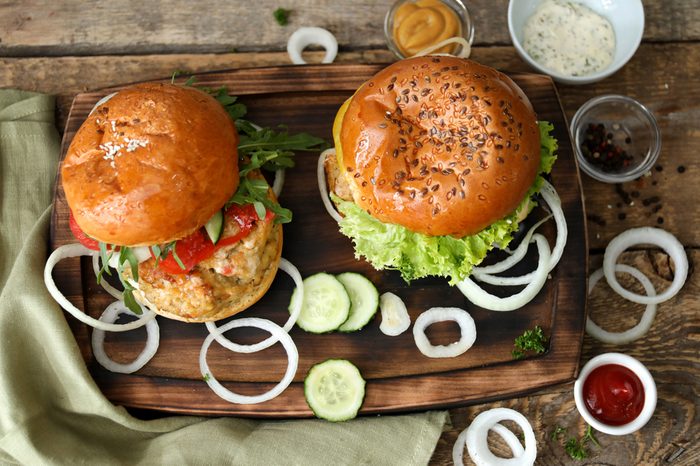 Tasty turkey burgers on wooden board