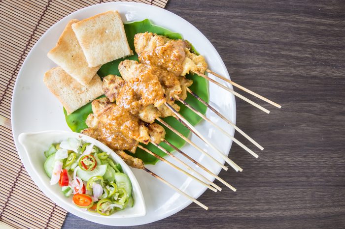 chicken satay with peanut suace, Pickles with are cucumber slices and onions in vinegar,Top view.