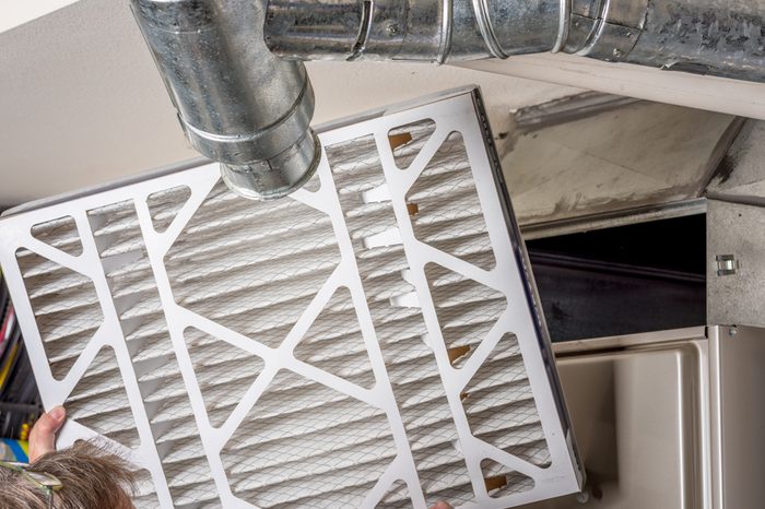 Handyman inspects a filter from a home furnace