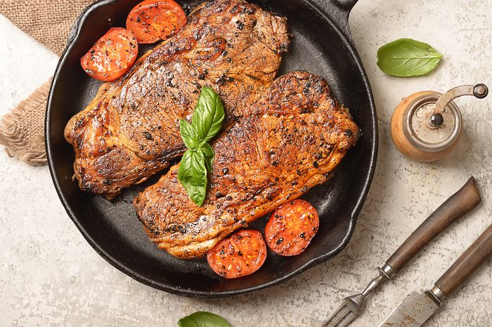 grilled steak and basil on a frying pan