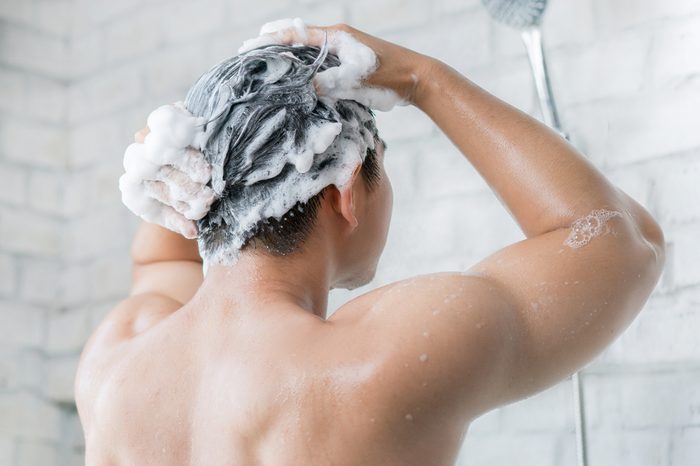The man is washing his hair, he use shampoo.