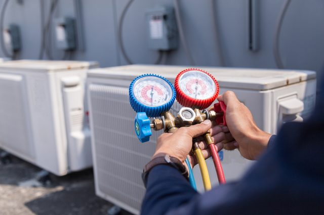 Technician is checking air conditioner ,measuring equipment for filling air conditioners.