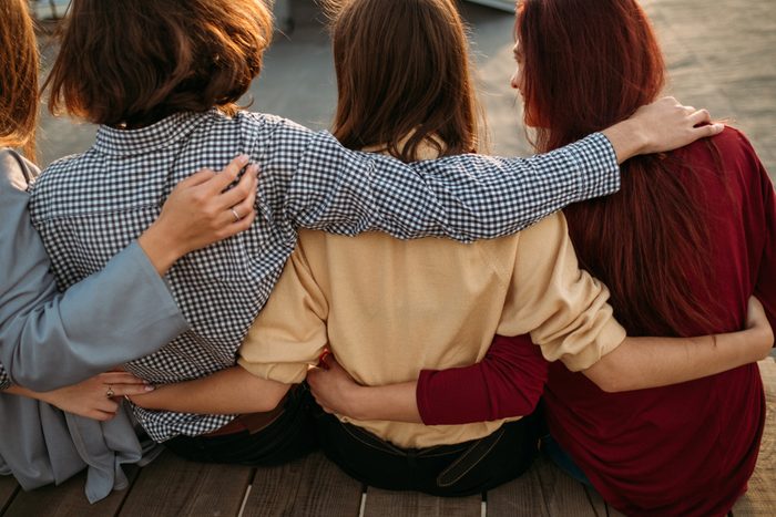 Pastime collaboration lifestyle teenage. Back view of young diverse people group. Arm around. Unity support. Friendship togetherness