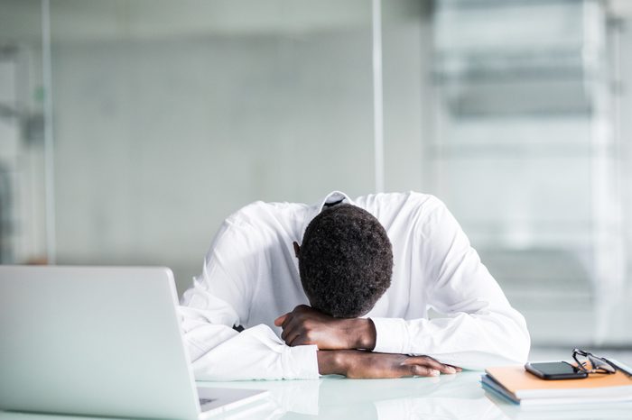 Tired African American employee in formal wear fall asleep after long working hours in office