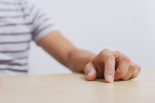 Adult man hand finger tapping on table 