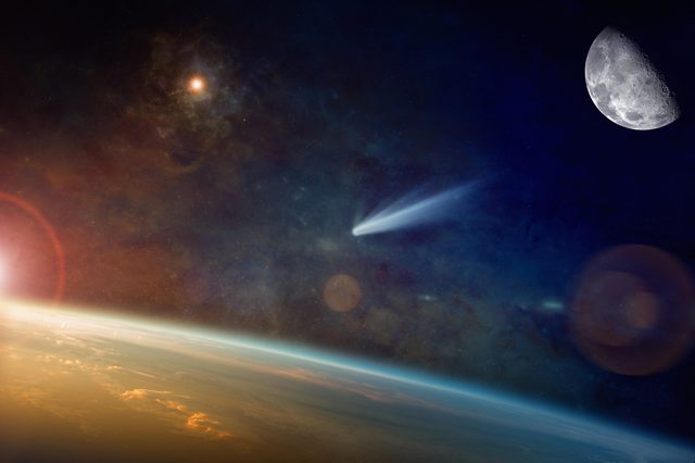 Astronomical scientific background - bright comet approaching to planet Earth in space. Elements of this image furnished by NASA.