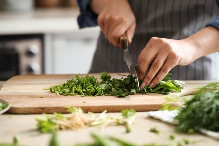 Cooking. Chef is cutting greens in the kitchen