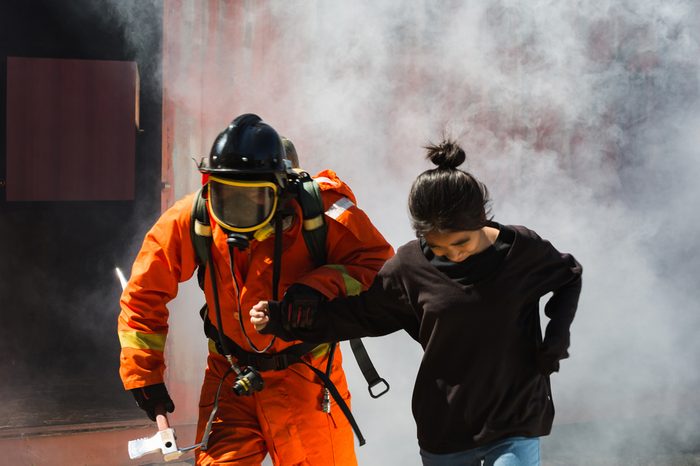 Firefighter help the Asian child in the burning warehouse / Fire and rescue training school regularly to get ready. 